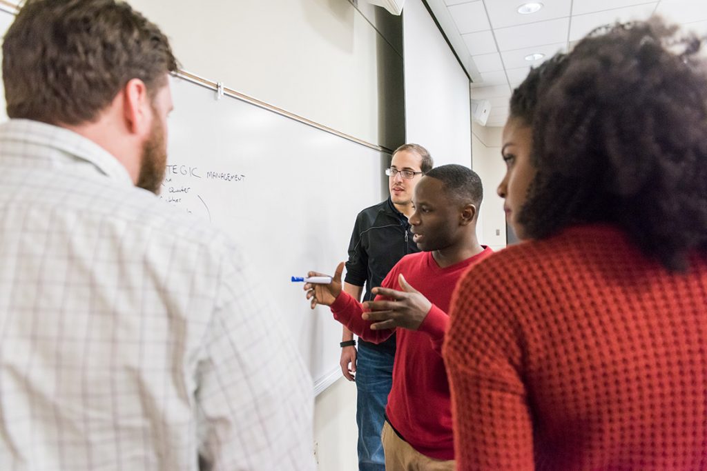 Students collaborating together on a white board