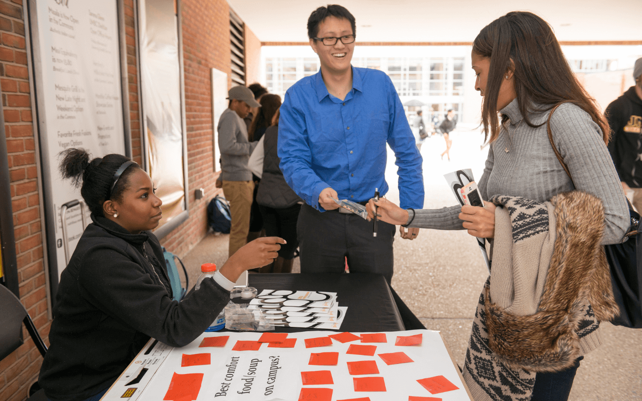 UMBC students displaying leadership skills on campus running a table for the Department of Professional Studies