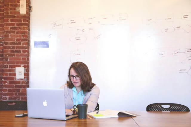 A project manager working on her laptop in an office. 