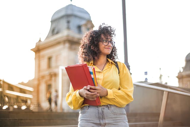 Smiling college student holding books
